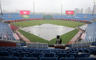 A masked broadcaster stands by at the Taoyuan Baseball stadium before the opening match for the Chinese Professional Baseball League (CPBL) in Taoyuan on April 11, 2020. - The match is called off due to the heavy rain. (Photo by Alex Lee / AFP) (Photo by ALEX LEE/AFP via Getty Images)