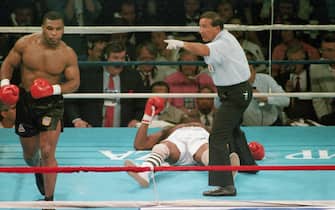 (Original Caption) 6/27/1988-Atlantic City, New JerseyReferee Frank Capuccino waves Mike Tyson to a neutral corner after he knocked out Michael Spinks in the first round.