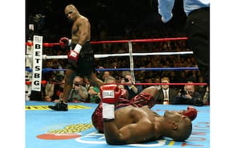 Mike Tyson (L) looks back at Clifford Etienne after knocking him to the mat in the first round of their heavyweight fight 22 February 2003 at the Pyramid Arena in Memphis, TN. Tyson knocked out Etienne 49 seconds into the round.   AFP PHOTO/Jeff HAYNES (Photo credit should read JEFF HAYNES/AFP via Getty Images)