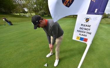 SOUTHEND ON SEA, ENGLAND -  MAY 13:   A safety sign on the flag  saying "Please do not touch the flags" as a golfer plays as shot on the green as golf courses reopen in England under government guidelines during the Coronavirus (COVID-19) pandemic at Thorpe Hall golf course on May 13, 2020 in Southend on Sea, England. The prime minister announced the general contours of a phased exit from the current lockdown, adopted nearly two months ago in an effort curb the spread of Covid-19. (Photo by John Keeble/Getty Images)
