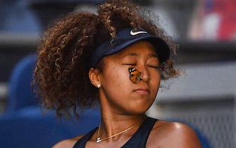 TOPSHOT - A butterfly lands on Japan's Naomi Osaka as she plays against Tunisia's Ons Jabeur during their women's singles match on day five of the Australian Open tennis tournament in Melbourne on February 12, 2021. - -- IMAGE RESTRICTED TO EDITORIAL USE - STRICTLY NO COMMERCIAL USE -- (Photo by Paul CROCK / AFP) / -- IMAGE RESTRICTED TO EDITORIAL USE - STRICTLY NO COMMERCIAL USE -- (Photo by PAUL CROCK/AFP via Getty Images)