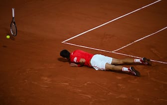 TOPSHOT - Serbia's Novak Djokovic reacts after falling on the court while playing against Italy's Matteo Berrettini during their men's singles quarter-final tennis match on Day 11 of The Roland Garros 2021 French Open tennis tournament in Paris on June 9, 2021. (Photo by Christophe ARCHAMBAULT / AFP) (Photo by CHRISTOPHE ARCHAMBAULT/AFP via Getty Images)