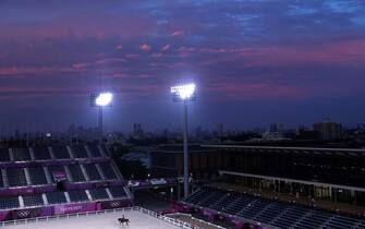 1234213586 TOPSHOT - A rider attends evening training before the city skyline during the Tokyo 2020 Olympic Games at the Equestrian Park in Tokyo on July 26, 2021. (Photo by Behrouz MEHRI / AFP) (Photo by BEHROUZ MEHRI/AFP via Getty Images)