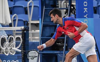 TOPSHOT - Serbia's Novak Djokovic smashes his racket during his Tokyo 2020 Olympic Games men's singles tennis match for the bronze medal against Spain's Pablo Carreno Busta at the Ariake Tennis Park in Tokyo on July 31, 2021. (Photo by Tiziana FABI / AFP) (Photo by TIZIANA FABI/AFP via Getty Images)