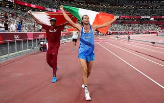 TOPSHOT - Gold medalists Mutaz Essa Barshim (L) of Team Qatar and Gianmarco Tamberi of Team Italy celebrate on the track following the Men's High Jump Final during the Tokyo 2020 Olympic Games at the Olympic Stadium in Tokyo on August 1, 2021. (Photo by Christian Petersen / POOL / AFP) (Photo by CHRISTIAN PETERSEN/POOL/AFP via Getty Images)
