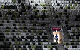 TOPSHOT - A police officer is seen in the empty stands ahead of the opening ceremony of the Tokyo 2020 Olympic Games, at the Olympic Stadium, in Tokyo, on July 23, 2021. (Photo by Martin BUREAU / AFP) (Photo by MARTIN BUREAU/AFP via Getty Images)
