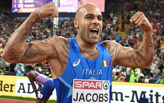 epa10124936 Lamont Marcell Jacobs of Italy celebrates after winning the men's 100m final during the Athletics events at the European Championships Munich 2022, Munich, Germany, 16 August 2022. The championships will feature nine Olympic sports, Athletics, Beach Volleyball, Canoe Sprint, Cycling, Artistic Gymnastics, Rowing, Sport Climbing, Table Tennis and Triathlon.  EPA/CHRISTIAN BRUNA