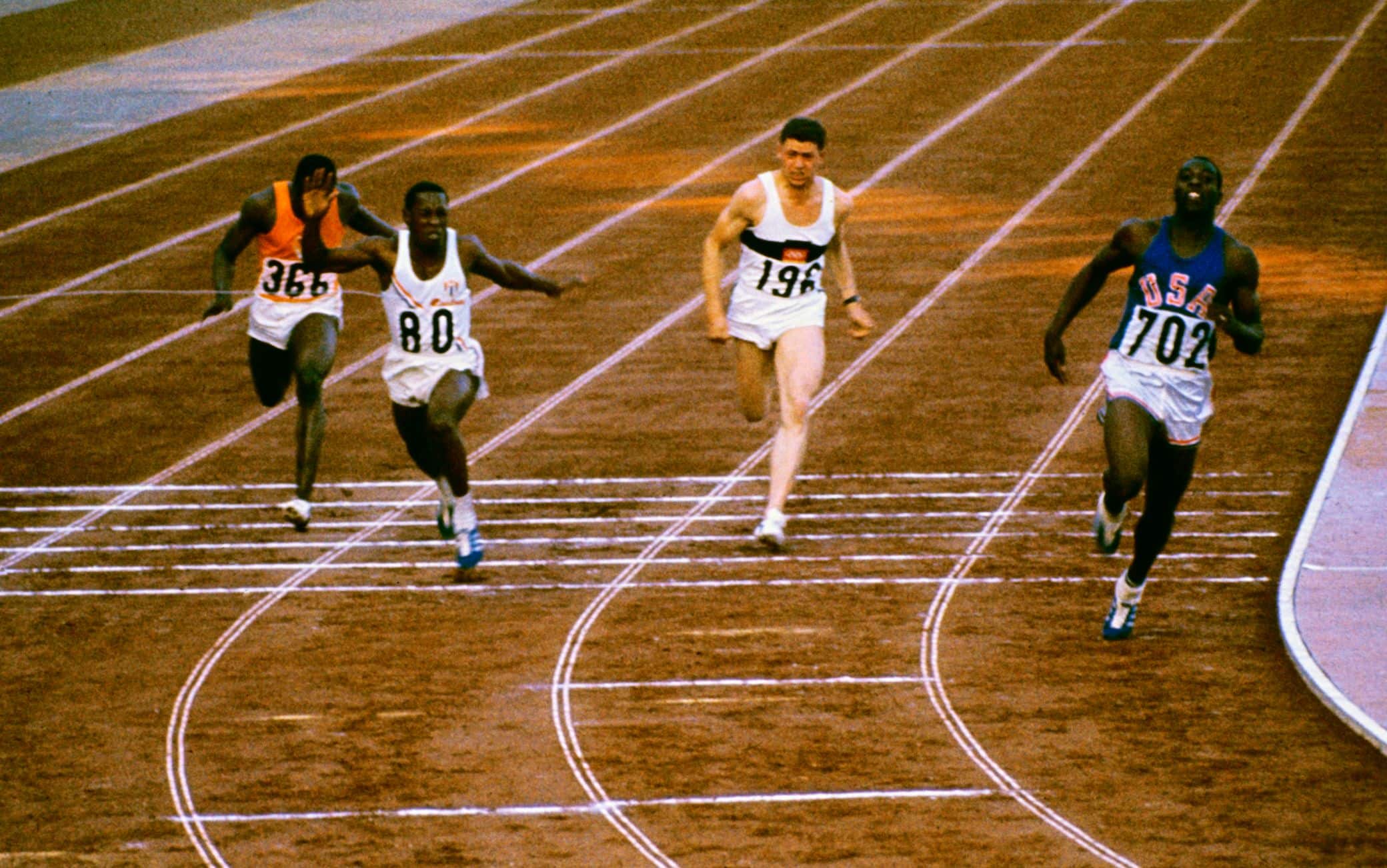 Bob Hayes taglia il traguardo nella finale dei 100 metri a Tokio, due scarpe solo apparentemente identiche: una chiodata, una da jogging 