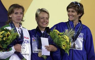 EDMONTON, CANADA:  Winners of the women's 20k walk (L-R): silver medal winner Valentina Tsybulskaya of Belarus, gold medal winner Olimpiada Ivanova of Russia, and bronze medal winner Elisabetta Perrone of Italy stand on the podium for the medals ceremony at the 8th World Championships in Athletics 09 August, 2001 at the Commonwealth Stadium in Edmonton, Canada.  AFP PHOTO/Don EMMERT (Photo credit should read DON EMMERT/AFP via Getty Images)