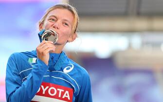 Silver medallist Italy's Valeria Straneo kisses her medal on the podium during the medal ceremony for the women's marathon at the 2013 IAAF World Championships at the Luzhniki stadium in Moscow on August 10, 2013. AFP PHOTO / ALEXANDER NEMENOV (Photo by Alexander NEMENOV / AFP) (Photo by ALEXANDER NEMENOV/AFP via Getty Images)