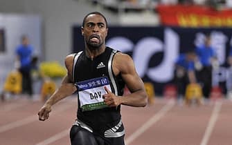 Tyson Gay of the USA (L) crosses the finish line ahead of Jamaican former world record holder Asafa Powell (C) in the men's 100 meters event of the Golden Grand Prix in Shanghai on September 20, 2009.   AFP PHOTO / ANDREW ROSS (Photo credit should read ANDREW ROSS/AFP via Getty Images)