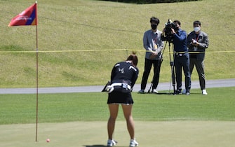 Members of the media take video footage of a South Korea golfer on the 18th green during a practice session ahead of the 42nd KLPGA Championship at Lakewood Country Club in Yangju, northeast of Seoul, on May 13, 2020. - Leading professional golfers will return to competitive action for the first time in months after the coronavirus shutdown when three of the world's top 10 women tee off in South Korea on May 14. (Photo by Jung Yeon-je / AFP) (Photo by JUNG YEON-JE/AFP via Getty Images)