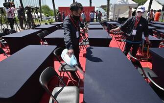 A staff sprays disinfectant on tables and seats before a press conference ahead of the 42nd KLPGA Championship at Lakewood Country Club in Yangju, northeast of Seoul, on May 13, 2020. - Leading professional golfers will return to competitive action for the first time in months after the coronavirus shutdown when three of the world's top 10 women tee off in South Korea on May 14. (Photo by Jung Yeon-je / AFP) (Photo by JUNG YEON-JE/AFP via Getty Images)