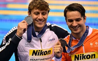 Silver medallists Italy's Nicolo Martinenghi (L) and Netherlands' Arno Kamminga pose after the medals ceremony for the men's 100m breaststroke swimming event during the World Aquatics Championships in Fukuoka on July 24, 2023. (Photo by MANAN VATSYAYANA / AFP) (Photo by MANAN VATSYAYANA/AFP via Getty Images)