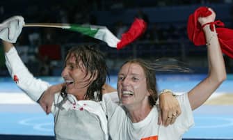 epa000254742 Valentina Vezzali (R) of Italy and compatriot Giovanna Trillini wave national flags after the women's individual Foil final at the Athens 2004 Olympic Games, Wednesday 18 August 2004. Vezzali won the gold medal, Trillini silver and Poland's Sylwia Gruchala won the bronze medal.    epa/dpa  Jens Wolf EPA/Jens Wolf