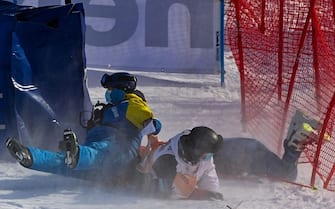 US Tommy Ford (R) lays on the ground after falling on the track's members of staff while competing in the round 1 of the Men's Giant Slalom race during the FIS Alpine ski World Cup on January 9, 2021, in Adelboden. (Photo by Fabrice COFFRINI / AFP) (Photo by FABRICE COFFRINI/AFP via Getty Images)