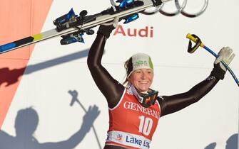 epa03980271 Elena Fanchini of Italy celebrates on the podium after placing third the Women's Downhill race at the FIS Alpine Skiing World Cup in Lake Louise, Alberta, Canada, 06 December 2013.  EPA/MIKE STURK
