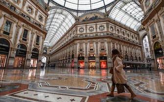 TOPSHOT - A general view shows a woman walk across the deserted Vittorio Emanuele II galleria shopping mall on March 10, 2020 in Milan. - Italy imposed unprecedented national restrictions on its 60 million people on March 10, 2020 to control the deadly coronavirus, as China signalled major progress in its own battle against the global epidemic. (Photo by Miguel MEDINA / AFP) (Photo by MIGUEL MEDINA/AFP via Getty Images)