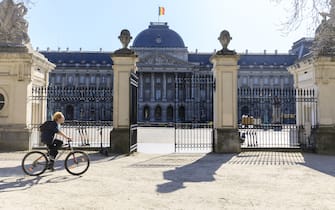 BRUSSELS, BELGIUM - MARCH 23: A man rides his bicycle in front of the Royal Palace of Brussels (Palais Royal de Bruxelles - Koninklijk Paleis van Brussel) on March 23, 2020 in Brussels, Belgium. Belgium government announced more measures asking all citizens to stay home and non-essential shops to close doors. 37 people have died in Belgium from Coronavirus disease 2019 (COVID-19 - SARS-CoV-2), with 2275 confirmed patients. (Photo by Thierry Monasse/Getty Images)