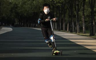 WUHAN, CHINA - APRIL 13: A boy rides a scooter on April 13, 2020 in Wuhan, Hubei Province, China. Despite the partial lift of the 76 day long lockdown, Wuhan's residential communities are still strictly controlling the flow of people. (Photo by Getty Images)