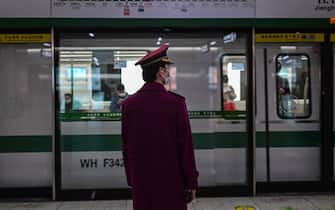 A subway worker wearing a facemask stands on a platform in a subway station in Wuhan, in China's central Hubei province on April 13, 2020. (Photo by Hector RETAMAL / AFP) (Photo by HECTOR RETAMAL/AFP via Getty Images)