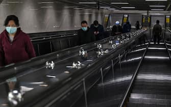 People wearing facemasks use the scalators in the subway in Wuhan, in China's central Hubei province on April 13, 2020. (Photo by Hector RETAMAL / AFP) (Photo by HECTOR RETAMAL/AFP via Getty Images)