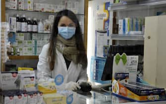 Una farmacista dietro il banco ad Ancona, 12 marzo 2020.
ANSA/Stefano Sacchettoni