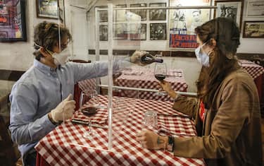 Valerio Calderoni, owner of a italian tipical restaurant, and his wife Martina, pose for a picture during a test for a of possible plexiglass separator between tables of restaurant ''Il Ciak'', Trastevere district in Rome, Italy, 23 April 2020. Countries around the world are taking measures to stem the widespread of the SARS-CoV-2 coronavirus which causes the Covid-19 disease. ANSA / FABIO FRUSTACI