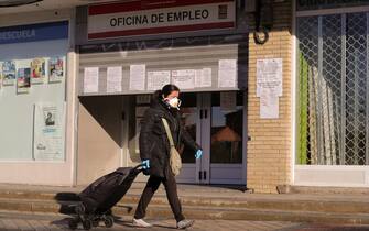 epa08338097 A woman protected with a mask and gloves walks past a public employment office as she goes to do the shopping in Madrid, Spain, 02 April 2020. The unemployment rose in more than 300,000 people in March to reach 3.5 million, due to the impact of the lockdown caused by coronavirus outbreak. Spain faces the 19th consecutive day of mandatory home confinement in a bid to slow down the spread of the pandemic COVID-19 disease caused by the SARS-CoV-2 coronavirus.  EPA/JUANJO MARTIN