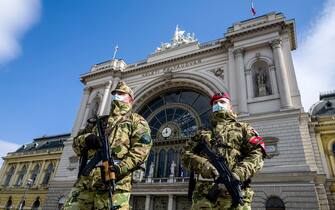 In this picture taken on March 24, 2020, Hungarian soldiers stand on guard wearing protective masks in front of the Keleti (Eastern) railway station in Budapest, amid the spread of the novel coronavirus COVID-19 pandemic. (Photo by KAROLY ARVAI / POOL / AFP) (Photo by KAROLY ARVAI/POOL/AFP via Getty Images)