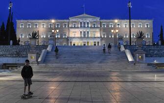 TOPSHOT - A boy skates in front of the Greek parliamemt in Athens, on May 1, 2020 after MayDay demonstrations staged in Athens, amid the country's lockdown to stem the spread of the COVID-19 outbreak caused by novel coronavirus. - Greece prepares for a gradual easing of its lockdown next week, with compulsory use of face mask in public transport and closed spaces, including shops. (Photo by Louisa GOULIAMAKI / AFP)