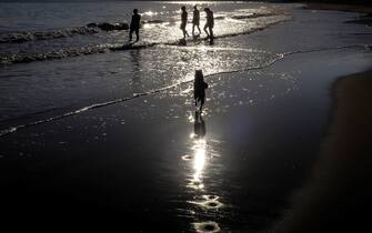 SPAIN WEATHER epa07468138 A general view of people walking in front of the sea at sunset in Ondarreta beach, San Sebastian, Spain, 28 March 2019. According to meteorologists, temperatures are not expected to shift throughout the day, with few clouds and a light wind blowing predominantly from the north. EPA/Javier Etxezarreta