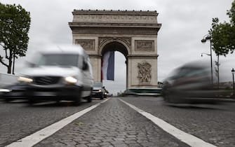 epa08413929 A photo taken using a slow shutter speed shows cars driving by the Arc de Triomphe on Champs Elysee avenue in Paris, France, 11 May 2020. France began a gradual easing of its lockdown measures and restrictions amid the COVID-19 pandemic.  EPA/IAN LANGSDON