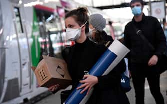 Passengers wearing protective facemasks arrive at Saint-Lazare Railway Station in Paris on May 11, 2020, on the first day of France's easing of lockdown measures in place for 55 days to curb the spread of the COVID-19 pandemic, caused by the new coronavirus. (Photo by BERTRAND GUAY / AFP)