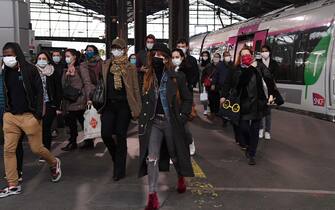 Passengers wearing protective facemasks arrive at Saint-Lazare Railway Station in Paris on May 11, 2020, on the first day of France's easing of lockdown measures in place for 55 days to curb the spread of the COVID-19 pandemic, caused by the new coronavirus. (Photo by BERTRAND GUAY / AFP)