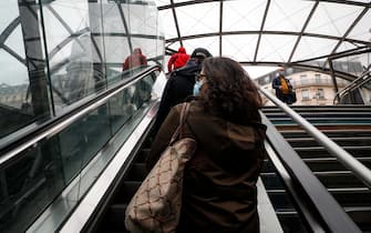Commuters wearing masks take an escalator at a metro station on May 11, 2020 in Paris, on the first day of France's easing of lockdown measures in place for 55 days to curb the spread of the COVID-19 pandemic, caused by the novel coronavirus. (Photo by GEOFFROY VAN DER HASSELT / AFP)