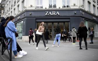 epa08414287 Customers wearing protective face masks queue outside a Zara store before reopening on the Champs Elysee avenue in Paris, France, 11 May 2020. France began a gradual easing of its lockdown measures and restrictions amid the COVID-19 pandemic.  EPA/JULIEN DE ROSA