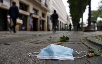 epa08414444 A face mask is seen on the floor on the Champs Elysee avenue in Paris, France, 11 May 2020. France began a gradual easing of its lockdown measures and restrictions amid the COVID-19 pandemic.  EPA/IAN LANGSDON