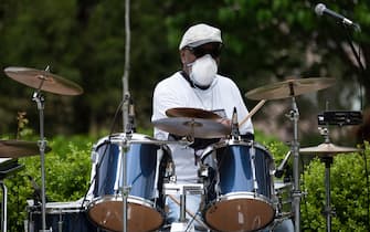 The drummer of the DC area motown band"The Tribe" plays a social distance concert in the parking lot of  the Goodwin House senior living community during the coronavirus pandemic, in Arlington, Virginia on April 14, 2020. (Photo by ANDREW CABALLERO-REYNOLDS / AFP) (Photo by ANDREW CABALLERO-REYNOLDS/AFP via Getty Images)