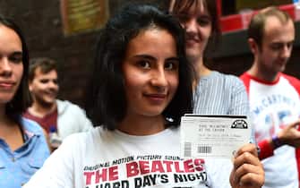 LIVERPOOL, ENGLAND - JULY 26:  A fan poses with a  ticket for the Paul McCartney gig at The Cavern Club, as the singer plays a one off gig at the legendary venue on July 26, 2018 in Liverpool, England. (Photo by Richard Martin-Roberts/Getty Images)