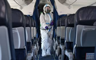 An employee wearing personal protective equipment disinfects a planes cabin at the Boryspil International Airport outside Kiev on June 13, 2020, while the airport prepares to restart regular international flights in line with an easing of coronavirus restrictions in Ukraine. (Photo by Genya SAVILOV / AFP) (Photo by GENYA SAVILOV/AFP via Getty Images)