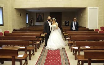 Maya Khadra and Rakan Ghossein (R) pose for a picture during their wedding at the church Our Lady Of Assistance in the village of Shemlan south of Beirut on April 25, 2020. - For months Maya and Rakan had looked forward to their dream wedding in the Vatican -- but the coronavirus pandemic forced them to settle for a tiny church ceremony in Lebanon. (Photo by ANWAR AMRO / AFP) (Photo by ANWAR AMRO/AFP via Getty Images)