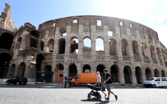 A family walk in front of the Colosseum, the largest amphitheater in the world as well as the most imposing monument of ancient Rome, located in the center of Rome, Italy, 19 May 2020. Italy is gradually easing lockdown measures implemented to stem the spread of the SARS-CoV-2 coronavirus that causes the COVID-19 disease.  ANSA / ETTORE FERRARI