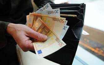 A Slovak counts euro bills after a withdrawal at an automatic teller machine in Bratislava on December 7, 2011.             AFP PHOTO / SAMUEL KUBANI (Photo credit should read SAMUEL KUBANI/AFP via Getty Images)