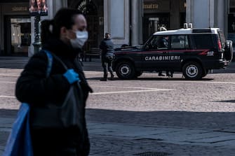 TURIN, ITALY - MARCH 19: Carabinieri agents check in Piazza San Carlo in Turin during on the Italy Continues Nationwide Lockdown To Control Coronavirus Pandemic on March 19, 2020 in Turin, Italy. The Italian government continues to enforce the nationwide lockdown measures to control the spread of COVID-19. (Photo by Stefano Guidi/Getty Images)