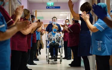 epa08869683 Margaret Keenan, 90, is applauded by staff as she returns to her ward after becoming the first person in the United Kingdom to receive the Pfizer/BioNtech covid-19 vaccine at the start of the largest ever immunisation programme in the UK's history, at University Hospital, Coventry, Britain, 08 December 2020.  EPA/Jacob King / POOL