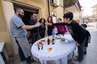 CORIGLIANO-ROSSANO, COSENZA, ITALY - 2020/04/13: A family toasts with wine as it prepares to celebrate Easter Monday even in this period when Coronavirus (COVID-19) affects the whole world. They are in the family and therefore do not use masks and gloves to protect themselves from the virus infection. They also celebrate to overcome the fear of this pandemic. (Photo by Alfonso Di Vincenzo/KONTROLAB/LightRocket via Getty Images)