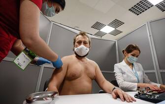 1231687792 Zenit supporter (C) receives a dose of the Sputnik V vaccine against COVID-19 at newly opened vaccination center operating at the stadium ahead of the Russian Premier League match between FC Zenit Saint Petersburg and FC Akhmat Grozny on March 13, 2021 at Gazprom Arena in Saint Petersburg, Russia. (Photo by Mike Kireev/NurPhoto via Getty Images)