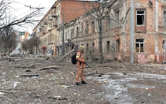 TOPSHOT - A member of the Ukrainian Territorial Defence Forces looks at destructions following a shelling in Ukraine's second-biggest city of Kharkiv on March 7, 2022. - On the 12th day of Russia's invasion of Ukraine March 7, 2022, Russian forces pressed a siege of the key southern port of Mariupol and sought to increase pressure on the capital Kyiv. Kyiv remains under Ukrainian control as does Kharkiv in the east, with the overall Russian ground advance little changed over the last 24 hours in the face of fierce Ukrainian resistance. (Photo by Sergey BOBOK / AFP) (Photo by SERGEY BOBOK/AFP via Getty Images)