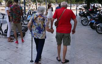 Milano, Coppia di anziani camminano mano nella mano in Piazza Duca D' Aosta (MILANO - 2021-08-10, DUILIO PIAGGESI) p.s. la foto e' utilizzabile nel rispetto del contesto in cui e' stata scattata, e senza intento diffamatorio del decoro delle persone rappresentate